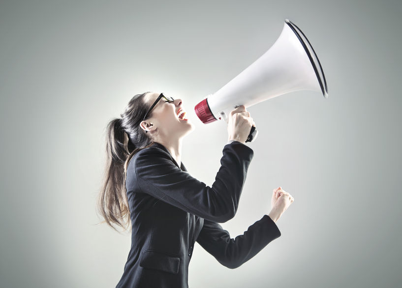 38886346 - portrait of a pretty businesswoman yelling over the megaphone