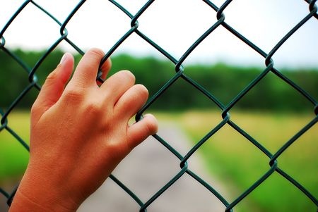 hand on chain-link fence